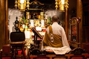 a man sitting in a chair in a room at 宿坊 端場坊｜Temple Hotel Habanobo in Minobu