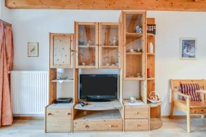 Habitación con TV en un armario de madera. en Katharinenhof Ferienwohnung Zugspitze (5), en Garmisch-Partenkirchen