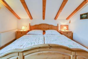 una camera con letto in legno e 2 comodini di Katharinenhof Ferienwohnung Zugspitze (5) a Garmisch-Partenkirchen