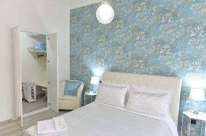 um quarto com uma cama e uma parede azul em Casa della Cattedrale em Asti