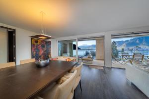 a living room with a dining table and a couch at Luxury Apartment Lake View & Center of Montreux by GuestLee in Montreux