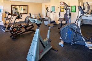 a gym with several treadmills and exercise bikes at Ramada by Wyndham Tucson in Tucson