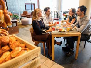 a group of people sitting at a table in a bakery at Aparthotel Adagio Muenchen City in Munich