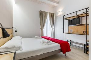 a bedroom with a bed with a red blanket on it at Scicli Albergo Diffuso in Scicli