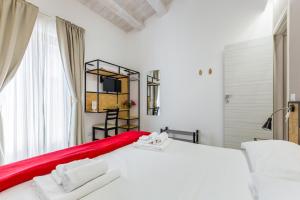 a bedroom with a large white bed and a window at Scicli Albergo Diffuso in Scicli