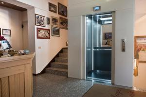 un pasillo con una puerta de cristal que conduce a una escalera en Albergo Meublè Victoria, en Auronzo di Cadore