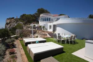 a white house with a lawn with a table and chairs at Sueño Azul in Jávea