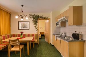 a kitchen and a dining room with a table at RAFFL APART in Sankt Anton am Arlberg +19 photos