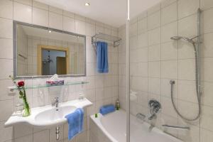 a white bathroom with a sink and a shower at RAFFL APART in Sankt Anton am Arlberg