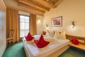 a hotel room with a bed with red pillows at RAFFL APART in Sankt Anton am Arlberg