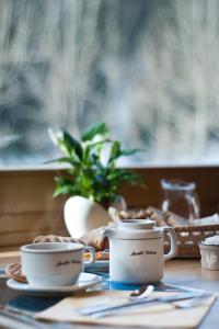 a table with two cups and a plate of food at Albergo Meublè Victoria in Auronzo di Cadore