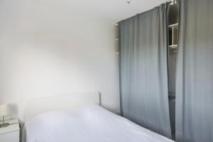 - une chambre avec un lit blanc et une fenêtre dans l'établissement Appartement Soleil d'Antibes - Welkeys, à Antibes