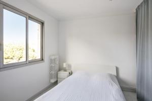 - une chambre blanche avec un lit et une fenêtre dans l'établissement Appartement Soleil d'Antibes - Welkeys, à Antibes