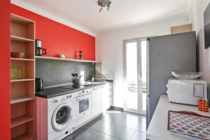 cocina con lavadora y pared roja en Appartement Soleil d'Antibes - Welkeys, en Antibes 4 fotos más