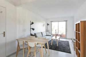 una sala de estar con una mesa y un sofá en Appartement Soleil d'Antibes - Welkeys, en Antibes