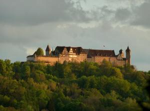 a castle on top of a hill with trees at Ferienwohnungen Vesteblick in Dörfles