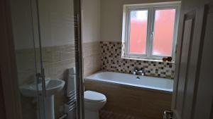 a bathroom with a tub and a toilet and a sink at Cooks Row in Scarborough +7 photos