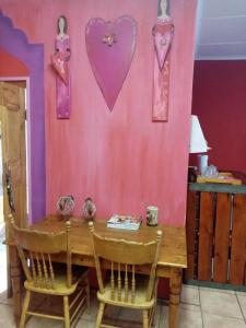 Pokój ze stołem i różową ścianą w obiekcie Oornagkamers@Hillstraat10 w mieście Douglas