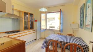 una cucina con tavolo e tavolo e una finestra di EM Holiday Apartment a Quartu SantʼElena