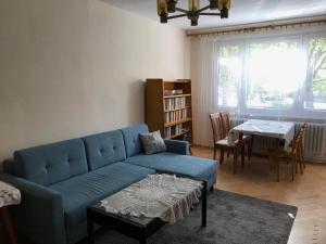 a living room with a blue couch and a table at Sunny appartment by the river in Dolný Kubín