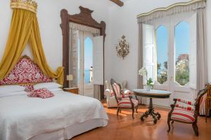 波西塔諾的住宿－帕拉索穆拉特酒店，卧室配有一张床和一张桌子及椅子
