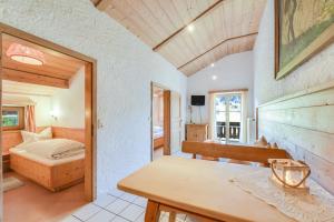 ein Schlafzimmer mit einem Bett und einem Tisch in einem Zimmer in der Unterkunft Jaudenhof - Apartment Hochalm in Lenggries