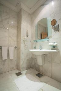 uma casa de banho com um lavatório e um chuveiro com um espelho. em Lahoya Homes em Beirute