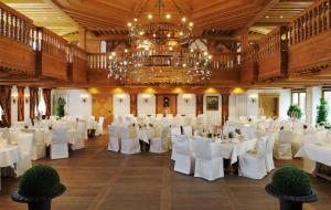 a banquet hall with white tables and a chandelier at Landhotel RÖSSLE in Stimpfach