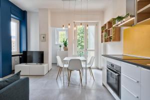 トリノにあるUrban House Carducci - Studiosのテーブルと椅子のあるキッチンとリビングルーム