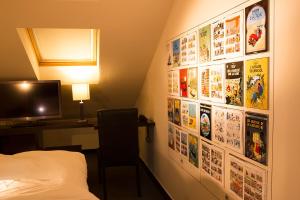a bedroom with a wall covered in movie posters at Hotel The Neufchatel in Brussels