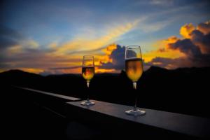 two glasses of wine sitting on a ledge with the sunset at Bella Villa Coron in Coron +83 photos