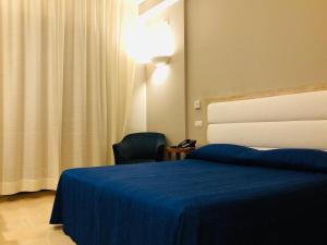 ein Hotelzimmer mit einem Bett und einem Stuhl in der Unterkunft Grand Hotel Ambasciatori Wellness & Spa in Chianciano Terme