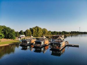 a group of boats docked at a dock on a river at die Möwen in Vetschau