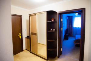 um quarto com um armário e uma porta de vidro em Mereke Hotel em Öskemen