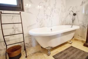 un bagno con vasca bianca e pareti in marmo di Le clos des Anges a Cogolin
