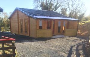 a small wooden cabin with a solar roof at Red Robins Nest in Galway