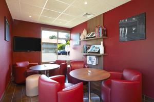 un restaurant rouge avec deux tables et des chaises rouges dans l'établissement Campanile Hotel Mont de Marsan, à Mont-de-Marsan