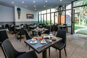 ナポリにあるVilla Elisio Hotel & Spaのテーブルと椅子が並ぶレストラン