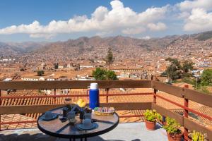 a table on a balcony with a view of a city at Samay Wasi Hostel I in Cusco
