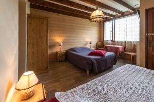 Un dormitorio con dos camas en una habitación con paredes de madera. en Les Sorbiers, en Montricher-le-Bochet