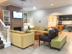 a living room with a couch and a table at Sonesta Essential IAH Airport JFK Boulevard - Newly Renovated in Houston