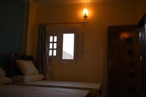 a bedroom with two beds and a window at Kosh royal house in Aswan