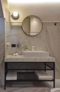een badkamer met een wastafel en een spiegel bij Atlas Aparthotel in Piatra Neamţ
