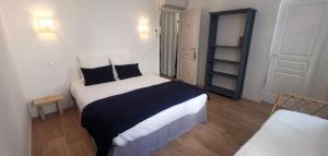 - une chambre avec un grand lit et des oreillers noirs et blancs dans l'établissement LA CENTENAIRE GRUISSAN - Maison d'Hôte, à Gruissan