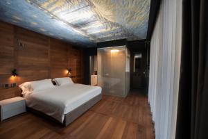 a bedroom with a white bed and a blue ceiling at Piajo Relax Hotel in Nembro