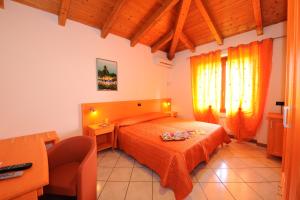 1 dormitorio con 1 cama con colcha de color naranja en Villa Camporosso en Colà di Lazise