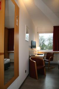 Zimmer mit einem Schreibtisch, Stühlen und einem Fenster in der Unterkunft Bildungszentrum Erkner in Erkner