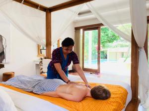 a woman giving a man a massage on a bed at Villa Anema Umalas in Seminyak