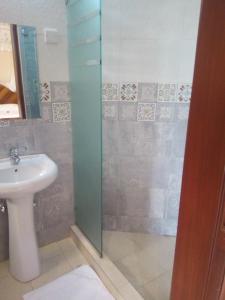 a bathroom with a sink and a shower at Emmaus Guesthouse Kampala in Kampala