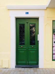 una puerta verde al lado de un edificio en Le Massilia comble en Vichy